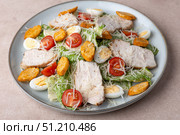 Caesar salad with chicken, cherry tomatoes, croutons, parmesan cheese, quail eggs and romaine lettuce. Traditional American dish. Close-up, selective focus. Стоковое фото, фотограф Наталья Любина / Фотобанк Лори