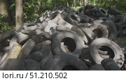In an area overwhelmed by discarded rubber tires, serious ecological issues arise as improper disposal leads to environmental disturbance and pollution. The situation highlights urgent concerns. Стоковое видео, видеограф Громов Александр / Фотобанк Лори