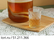 Kombucha tea fermenting in glass jar with scoby and a glass of kombucha on bamboo board. Стоковое фото, фотограф Дмитрий Цветков / Фотобанк Лори
