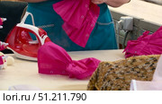 a seamstress scribbles clothes for dolls on a typewriter and smoothes it with an iron. Стоковое видео, видеограф Алексей Сергеев / Фотобанк Лори