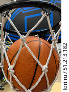 A closeup of a basketball falling through the net to score points. Стоковое фото, фотограф Регина Ерофеева / Фотобанк Лори