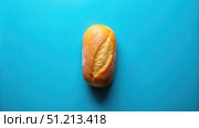 A Single Loaf of Bread on a Blue Background. Generative AI. Стоковое AI-изображение, AI-художник Roman Zavorotny / Фотобанк Лори