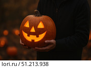 A Joyful Halloween Pumpkin with a Grinning Face, Illuminated from Within, Perfectly Capturing the Spirit of Autumn Festivities and Seasonal Celebrations. Стоковое AI-изображение, AI-художник Башкирова Анна / Фотобанк Лори