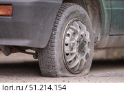 a flat tire of a car in close-up. Flat tire repair at a local tire service station during daytime in a residential area. Стоковое фото, фотограф Владимир Разгуляев / Фотобанк Лори