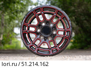 The cast disc is new from the SUV, black with red elements, auto parts wheel front view on the street. Стоковое фото, фотограф Владимир Разгуляев / Фотобанк Лори
