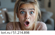 A young girl expresses shock as she reads surprising news, displaying a mix of emotions in her comfortable living room setting. Стоковое AI-видео, аниматор Данила Большаков / Фотобанк Лори