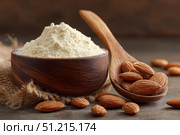 Almond flour. Almond nuts and almond flour in a wooden bowl and spoon. White table background. Grated almonds pile. Gluten-free produce for health. Low Carb Keto, celiac, paleo, and wheat-free diets. Стоковое AI-изображение, AI-художник Марина Демидюк / Фотобанк Лори