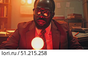 An expert shares intriguing insights and predictions while seated in a dimly lit office, illuminated by warm light and surrounded by books. Стоковое AI-видео, аниматор Данила Большаков / Фотобанк Лори