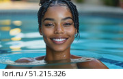 A woman with braided hair smiles widely while floating in a cool pool under the sun, showcasing her joyful and carefree spirit. Стоковое AI-видео, аниматор Данила Большаков / Фотобанк Лори