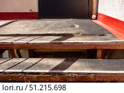 Warped and lifted porch surface with exposed reinforcement, indicating imminent structural failure from environmental stress. Стоковое фото, фотограф Дмитрий Коростылев / Фотобанк Лори