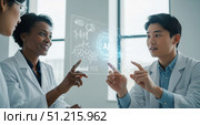 Scientists studying DNA structure on futuristic holographic interface, man and woman researchers working on genetics project in modern advanced laboratory. Стоковое AI-изображение, AI-художник Павел Муравьев / Фотобанк Лори