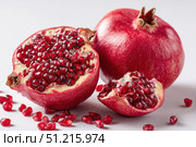 Pomegranates. Pomegranate isolated on a white transparent background. Juicy garnet fruit whole and its half with leaves and details. Piece of pomegranate with seeds. Side view. Freshness and abundance. Стоковое AI-изображение, AI-художник Марина Демидюк / Фотобанк Лори