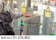 Young man scanning QR code on train ticket on turnstile scanner to board train at train station. Стоковое фото, фотограф Андрей Митин / Фотобанк Лори