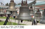 Large metal bells hanging outdoors with intricate details and blurred architectural background. Стоковое видео, видеограф Анастасия Золотницкая / Фотобанк Лори