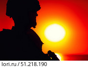 Silhouette of a soldier patrolling coastline at sunset. Oleg Zabielin / Stocktrek Images/TASS. Стоковое фото, агентство ТАСС / Фотобанк Лори