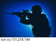 Silhouette of a soldier aiming assault rifle with collimator sight at night. Oleg Zabielin / Stocktrek Images/TASS. Стоковое фото, агентство ТАСС / Фотобанк Лори