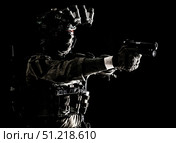 Modern soldier in combat uniform, helmet and radio headset, shooting handgun in the darkness. Oleg Zabielin / Stocktrek Images/TASS. Стоковое фото, агентство ТАСС / Фотобанк Лори