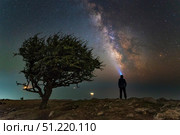 Explorer looking at the Milky Way from the coast of the Black Sea. Yuri Zvezdny/Stocktrek Images/TASS. Стоковое фото, агентство ТАСС / Фотобанк Лори