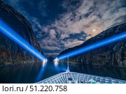 Ferry ship MS Trollfjord exiting the narrow strait by searchlight and under moonlight. Alan Dyer/Stocktrek Images/TASS. Стоковое фото, агентство ТАСС / Фотобанк Лори