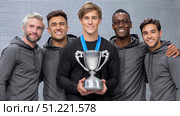 Male athletes in gray hoodies displaying championship medals, holding winning trophy, celebrating collective success with team spirit and athletic achievement. Стоковое AI-изображение, AI-художник Юрий Поздников / Фотобанк Лори