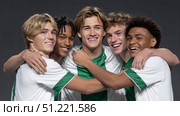 Soccer teammates wearing white and green uniforms celebrating together, sharing joyful embrace and displaying strong team bonding after victorious game or intense training. Стоковое AI-изображение, AI-художник Юрий Поздников / Фотобанк Лори