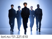 Fashion models walking confidently on runway, wearing sleek black attire, representing contemporary design trends with high end elegance and professional poise. Стоковое AI-изображение, AI-художник Юрий Поздников / Фотобанк Лори