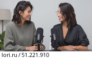 Female podcasters collaborating, sitting at table, wearing casual attire, recording podcast with microphones, sharing animated conversation. Стоковое AI-видео, аниматор Юрий Поздников / Фотобанк Лори