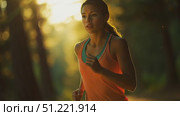 Muscular female athlete running during golden hour sunlight, navigating forest trail with intense athletic determination. Стоковое AI-видео, аниматор Юрий Поздников / Фотобанк Лори