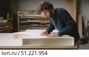 Experienced woodworker meticulously checking handcrafted wooden furniture surface, achieving precision and quality in rustic workshop setting. Стоковое AI-видео, аниматор Юрий Поздников / Фотобанк Лори