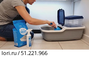 Responsible pet owner maintaining cat litter, scooping fresh litter, applying deodorizer for clean, odor free living space. Стоковое AI-видео, аниматор Юрий Поздников / Фотобанк Лори
