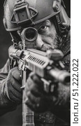 Special forces soldier wearing tactical gear, aiming high powered assault rifle with telescopic sight, displaying intense concentration and professional demeanor in monochrome visual. Стоковое AI-видео, аниматор Юрий Поздников / Фотобанк Лори