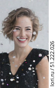 Colorful confetti raining down on glamorous woman wearing sparkling black sequin dress, beaming with joy against white background, embodying festive celebration. Стоковое AI-видео, аниматор Юрий Поздников / Фотобанк Лори