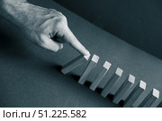 Domino has Fallen in a Row. Domino theory. Effect. Hand with Finger is Pointing and Pushing the Falling Wood Blocks. Risk Management, Revolution Concept. Affect Business. Closeup. Manifestation. Red. Стоковое фото, фотограф Марина Демидюк / Фотобанк Лори