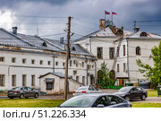 Вид со двора на здание с флагами России и Костромской области на крыше кирпичного дома в Костроме. Редакционное фото, фотограф Владимир Шипикин / Фотобанк Лори