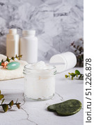 Beef tallow for skin care in a jar and massagers on the table vertical view. Стоковое фото, фотограф Елена Руй / Фотобанк Лори