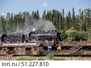An old Soviet steam locomotive of the L series. The Ruskeala Express retro train is on its way to the mountain park. Thick smoke is coming from the chimney. Russia, Republic of Karelia, Sortavala, August 10, 2025. Редакционное фото, фотограф Photojuli / Фотобанк Лори