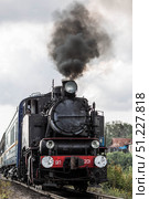 An old Soviet steam locomotive of the L series. The Ruskeala Express retro train is on its way to the mountain park. Thick smoke is coming from the chimney. Russia, Republic of Karelia, Sortavala, August 10, 2025. Редакционное фото, фотограф Photojuli / Фотобанк Лори