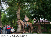 Русский богатырь на коне, люди на фоне скульптур сказочных персонажей в парке "Лога". Каменск–Шахтинский, Ростовская область, Россия (2020 год). Редакционное фото, фотограф Андрей Цыганков / Фотобанк Лори