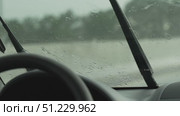 Rain Car Windshield: Rainy day view, wipers moving, water droplets obscure outside view. Стоковое видео, видеограф svetograph / Фотобанк Лори