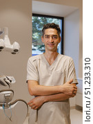 Confident Dentist in a Modern Clinic Setting Providing Exceptional Care and Support to Patients. Стоковое фото, фотограф Cantemir Dumitru / Фотобанк Лори
