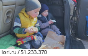 Two Young Children Delightfully Enjoying Tasty Snacks Together in a Cars Backseat. Стоковое видео, видеограф Olesia Kondrateva / Фотобанк Лори