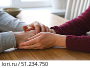 Couple holding hands at home. Happy Man and Woman. Two Loving Hands Together on the Couch Sharing Deep Affection and Love in Details. Intimate connection. Close-up of Intertwined female and male hands. Стоковое фото, фотограф Марина Демидюк / Фотобанк Лори