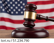 Американское правосудие - судебный молоток на фоне флага США. American justice - judicial gavel on the background of the US flag. Стоковое AI-изображение, AI-художник ketpro.design / Фотобанк Лори