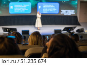 Speaker presenting at conference viewed from audience perspective in modern auditorium. Стоковое фото, фотограф Антон Гвоздиков / Фотобанк Лори