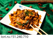 Stir Fried Rice Noodles With Beef Presentation on Vibrant Green Silk Fabric. Стоковое фото, фотограф Aleksandr Golubev / Фотобанк Лори