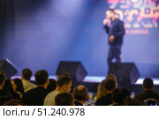 Speaker addressing audience during public event in blurred stage view. Стоковое фото, фотограф Антон Гвоздиков / Фотобанк Лори