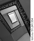 Abstract upward view of staircase with ornate iron railings. Стоковое фото, фотограф Антон Гвоздиков / Фотобанк Лори