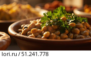 Steaming bowl of beans garnished with fresh parsley at a buffet. Стоковое фото, фотограф David Kashakhi / Фотобанк Лори