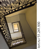 Looking upward through a decorative spiral staircase with elegant ironwork railings. Стоковое фото, фотограф Антон Гвоздиков / Фотобанк Лори