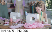 Young seamstress working on modern sewing machine in sewing workshop. Стоковое видео, видеограф Яков Филимонов / Фотобанк Лори